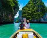 Para w łodzi podziwia turkusową wodę i skaliste wyspy. Idealna pogoda na Phuket w grudniu.