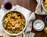 Un piatto rustico di fagioli e verdure, perfetto per scoprire cosa mangiare in Toscana. Accompagnato da vino rosso e olio d'oliva.