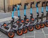 Une rangée de trottinettes électriques Helbiz, prêtes à l'emploi. Imaginez pouvoir debrider trottinette pour une balade urbaine !