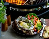 Fisk i folie på grillen, serverad med fräsch sallad och smörgås. En perfekt sommarmåltid att grilla fisk i folie.