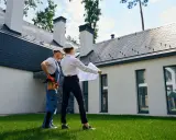 Architekt i budowlaniec omawiają plany domu. Czy można mieszkać w domu bez odbioru? To pytanie, na które odpowiedź znajdą, analizując projekt.