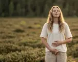 Kobieta z zamkniętymi oczami, ręce na brzuchu, w naturze. Czy to d mannoza co to jest?