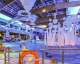 Wesoła zabawa w aquaparku w Sopocie, mnóstwo ludzi cieszy się basenem i atrakcjami. Warto sprawdzić aquapark Sopot opinie przed wizytą.