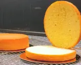 Trois génoises dorées sur une grille, prêtes pour le glaçage. Le temps de cuisson génoise est crucial pour leur texture aérienne.