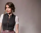 Eine Frau mit einer eleganten Dirndl-Frisur für kurze Haare trägt ein traditionelles Dirndl.
