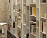 Eine weiße, modulare Bücherwand, perfekt für dein Projekt "Bibliothek selber bauen". Viele Bücher und Deko-Objekte sind ordentlich einsortiert.