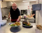Un chef présente des assiettes de frites, salade et curry, des spécialités normandie.