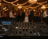 DJ sprzęt gotowy do akcji. W tle weselne tańce i migoczące światła. Czas na pytania do DJ-a o ulubione kawałki!