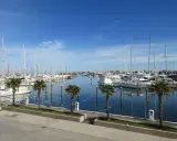 Porto turistico di San Giuliano Mare, Rimini, con barche a vela e yacht ormeggiati in un mare calmo sotto un cielo azzurro.