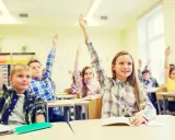 Engagierte Schüler im Unterricht heben eifrig die Hände.