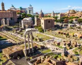 Antike Ruinen des Forum Romanum in Rom, 753 v. Chr. gegründet, mit Säulen, Bögen und Gebäuderesten unter blauem Himmel.