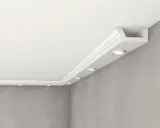 Elegancka listwa halogenowa z wbudowanymi punktami świetlnymi, tworząca nowoczesne oświetlenie sufitowe nad szarą, betonową ścianą.