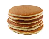 Pile de pancakes dorés faits maison avec de la farine complète, prêts à être dégustés.