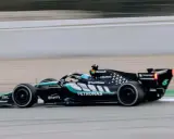El Aston Martin AMR26 negro y turquesa acelera en la pista, con el logo de Petronas visible.