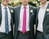 Groomsmen in grey suits with different colored ties. This image shows that you do not have to wear a tie to a wedding, but it's a stylish choice.