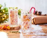 Festlicher Cocktail mit Kokosmilch, garniert mit einem Zuckerstangen-Lutscher und Früchten. Perfekt für die Weihnachtszeit.