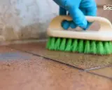 Guante azul cepilla suelo de baldosas para quitar cemento cola.