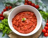 Frische tomaten pizza sauce, mit Basilikum und Knoblauch, umgeben von reifen Kirschtomaten.