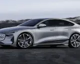 Silberner Audi A4 e-tron, ein elegantes Elektroauto, steht vor einer felsigen Küstenlandschaft.