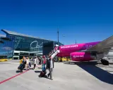 Pasażerowie wsiadają do różowego samolotu Wizz Air na jednym z portów lotniczych w Polsce.
