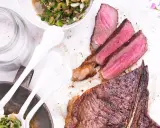 Perfekt gegrillter T-Bone-Steak, saftig rosa im Inneren, mit Beilagensalat und grobem Salz. Die t-bone steak zubereitung ist ein Genuss.