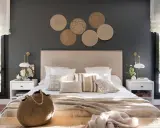 Decorar pared cabecero con fotos de mimbre crea un ambiente acogedor. Cama con cojines y manta tejida.