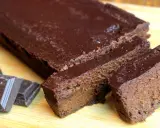 Un délicieux gâteau chocolat compote, coupé en tranches, avec des carrés de chocolat à côté.
