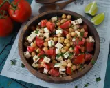 Ein köstlicher, **high protein salat** aus Kichererbsen, Tomaten und Feta in einer Holzschale, garniert mit Petersilie.