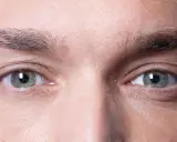 Gros plan sur les yeux d'un homme, mettant en valeur la forme naturelle de ses sourcils.
