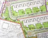 Plan zagospodarowania terenu z zaznaczonymi strefami zabudowy, zielenią, drogami i parkingami. Widoczne numery działek i oznaczenia budynków.