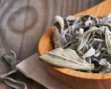 Get inspired for your next salbei rezepte! Getrocknete Salbeiblätter in einem Holzlöffel, bereit für köstliche Gerichte.
