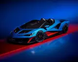 Ein blauer Lamborghini Veneno Roadster mit roten Akzenten steht auf einem glänzenden Boden, beleuchtet von rotem und blauem Licht.