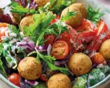 Bunter Salat mit Tomaten, Zwiebeln und Falafelbällchen. Ein schnelles gesundes Essen, das gut aussieht und schmeckt.