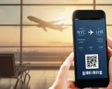 Bilet lotniczy na telefonie: lot z NYC do LHR, pasażer John, bramka 12. IATA co to? To kod lotniska.
