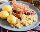 Une assiette de choucroute garnie, avec pommes de terre, saucisses et viande fumée. Un plat qui raconte une histoire culinaire.