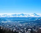 Zimowy krajobraz z górami w tle. Miasto pokryte śniegiem, idealne na zakopane atrakcje.