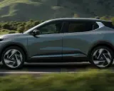 Nowy, elektryczny Mitsubishi Eclipse Cross sunie po malowniczej drodze, otoczony zielonymi wzgórzami.