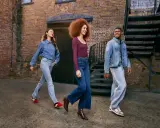 Three friends walk down an alleyway, showcasing how denim is breathable and stylish in various cuts and washes.