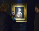 Dama z gronostajem Leonarda da Vinci, uwieczniona na zdjęciu przez turystkę. Obok obrazu stoi mężczyzna.