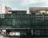 People gather on the rooftop of the Museum of Contemporary Art Denver, enjoying the city views. Photos of the museum showcase its modern architecture.