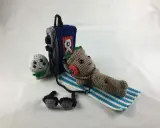 Amigurumi Baby Groot tumbado con auriculares junto a un reproductor de música y un pequeño personaje gris.
