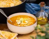 En skål med kycklingsoppa med nudlar och kycklingbitar, serverad med rostat bröd. Ett recept på kycklingsoppa som ser utsökt ut.