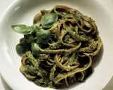 Herzhafte Bandnudeln mit cremiger Pistazien-Pesto-Sauce und frischem Basilikum garniert.