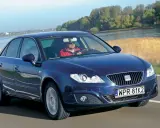 Granatowy Seat Exeo 2.0 TDI jedzie drogą nad rzeką, kierowca w czerwonej kurtce.