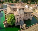 Castello di San Martino in Rio, uno dei tanti splendidi posti da visitare in Emilia Romagna, circondato da un fossato verde.