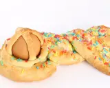 Dolci calabresi pasquali: un uovo incastonato in una treccia di pane dolce, decorata con zuccherini colorati.
