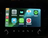 Ekran samochodu z ikonami aplikacji: Ustawienia, MEGOGO, Shell Recharge, Spotify, Waze, WhatsApp, YouTube Music. Działa system iOS CarPlay.