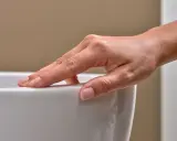 Eine Hand streicht über eine weiße Oberfläche. Mögliche Keratect Nachteile könnten hier eine Rolle spielen, wenn die Oberfläche empfindlich ist.