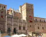 Impresionante catedral en Cáceres, con niños disfrutando de la plaza.
