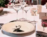 Un élégant dressage à la française pour un dîner de gala, avec une assiette ornée d'un cerf, des verres à pied et une carte de visite pour le Grand-Duc de Luxembourg.
